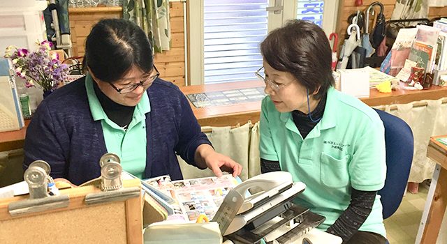 事務所で打ち合わせをするスタッフ